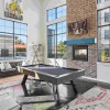 pool table and tv in a large room with many windows