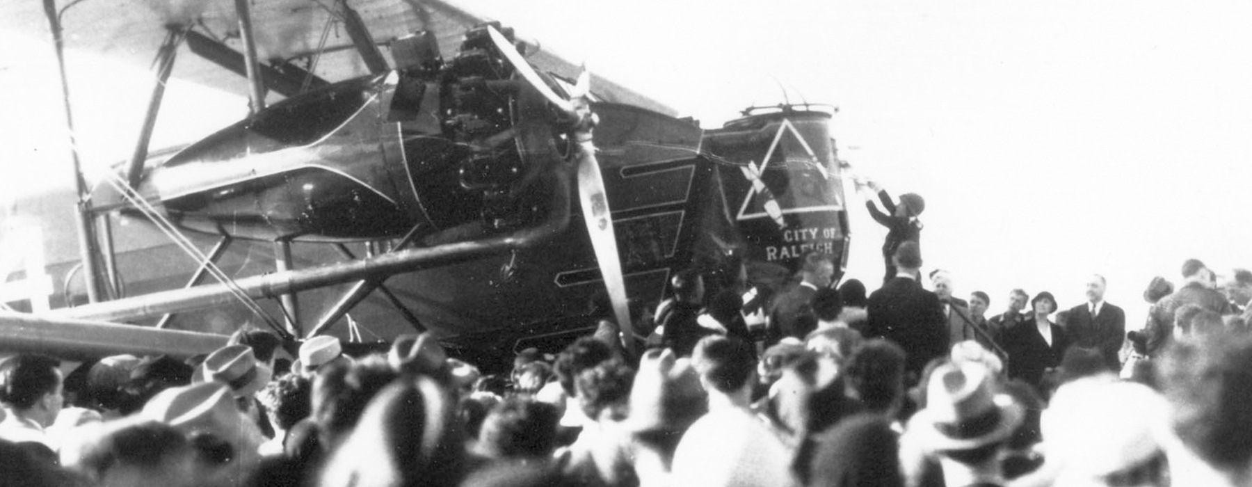 retro image of a pilot preparing their plane in front of a crowd